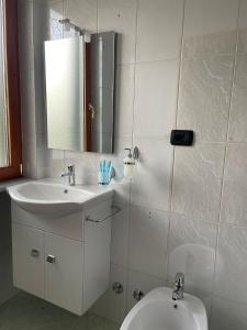 une salle de bain avec un lavabo, des toilettes et un miroir dans l'établissement Respiro di luna, à Pescopagano