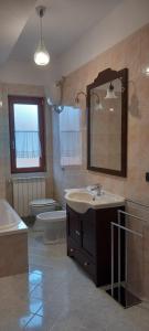 une salle de bains avec lavabo, baignoire et toilettes dans l'établissement Respiro di luna, à Pescopagano