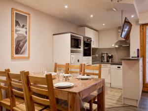 a kitchen and dining room with a wooden table and chairs at Appartement Centre-Ville avec Terrasse à Brides-les-Bains, Proche Télécabine et Spa - FR-1-512-138 in Brides-les-Bains