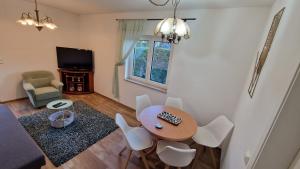 un soggiorno con tavolo, sedie e televisione di Ferienhaus Peitz a Peitz