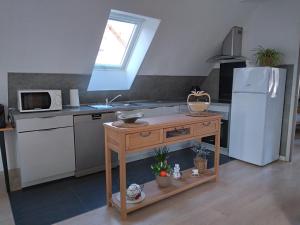 a kitchen with a sink and a white refrigerator at Le repos du facteur in Riquewihr +2 photos