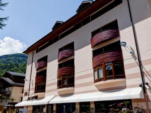 a building with painted windows and mountains in the background at Studio rénové au centre-ville avec balcon, parking et WIFI - 4 pers - FR-1-512-166 in Brides-les-Bains +10 photos