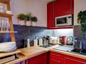 a kitchen with red cabinets and a counter top at Studio rénové 2* pour 4 pers, centre-ville avec parking et WiFi - FR-1-512-167 in Brides-les-Bains +12 photos
