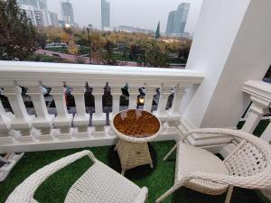 Un balcón con 2 sillas, una mesa y sillas en KARE Studio, en Tashkent