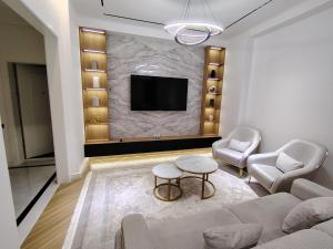 Una sala de estar con un sofá y sillas y un televisor. en KARE Studio, en Tashkent