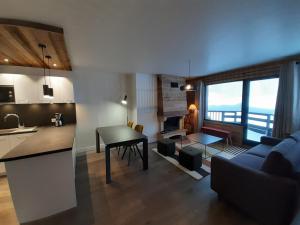 a kitchen and living room with a couch and a table at Moderne 3 pièces, balcon sud, centre station, pied des pistes – Courchevel - FR-1-513-23 in La Tania