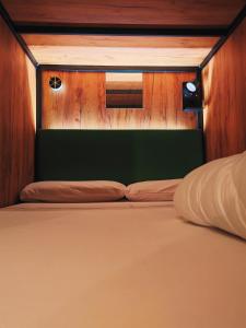 un letto chiuso con testiera in legno di Urban Inn Capsule Madrid a Madrid