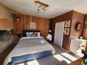 a bedroom with a large bed and wooden walls at Auberge Les Enguenelles Lodges in Châtelblanc