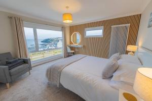 a bedroom with a large bed and a large window at The View at Portpatrick. in Portpatrick