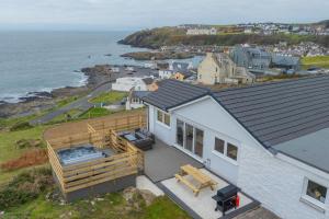 an aerial view of a house with a deck and the ocean at The View at Portpatrick. in Portpatrick