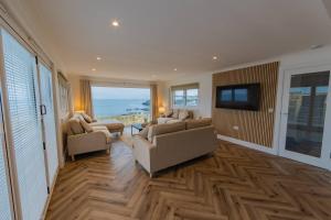 a living room with two couches and a flat screen tv at The View at Portpatrick. in Portpatrick