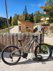 a bike parked next to a wooden fence at Auberge Les Enguenelles Lodges in Châtelblanc