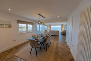 a dining room and living room with a table and chairs at The View at Portpatrick. in Portpatrick +19 photos