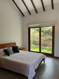 una camera da letto con un letto e una grande finestra di montaña serena a Villa de Leyva