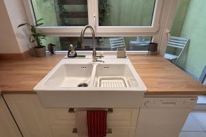 a white sink in a kitchen with a mirror at Beautiful apartment of 67 m2 near Strasbourg in Bischheim