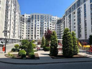 a park with trees and benches in front of a large building at Apartament Chișinău centru in Chişinău