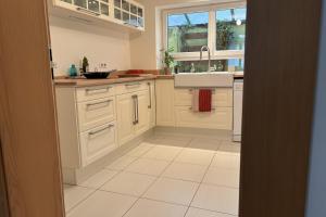 a kitchen with white cabinets and a sink at Beautiful apartment of 67 m2 near Strasbourg in Bischheim