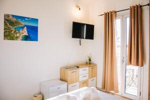 una camera da letto con un letto e una TV a parete di Da Battista Rooms a Baunei