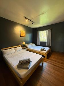 a bedroom with two beds and a window at Casa Encantada Lodge in Baguio