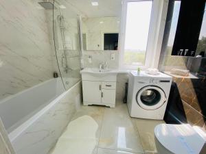 a bathroom with a washing machine and a sink at Apartament Chișinău centru in Chişinău +113 photos