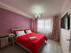 a bedroom with a red bed and a window at Apartament Chișinău centru in Chişinău