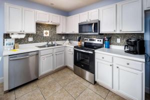 een keuken met witte kasten en een zwarte oven bij Sunset Cottages 1C Pet friendly cottage in Fort Walton Beach +29 foto's