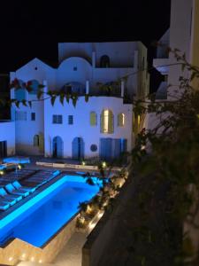 a villa with a swimming pool at night at Lorins Seaside Santorini in Drymades Beach in Gjilek