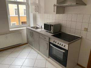 una cucina con forno a microonde e fornello forno superiore di Gemütliche Praktische Wohnungen a Gera