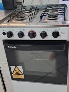 La cuisine est équipée d'un four avec plaques de cuisson. dans l'établissement Kitnet, à Campo Grande