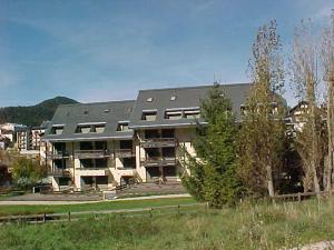 ein großes Gebäude auf einem Feld neben einem Park in der Unterkunft Studio cosy au pied des pistes avec balcon, proche centre et piscine, navette gratuite - FR-1-515-172 in Villard-de-Lans