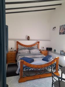 a bedroom with a wooden bed with blue pillows at La Casita Perlita in Arboleas
