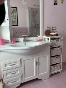 a bathroom with a white sink and a mirror at Mariuccia Home in Siracusa