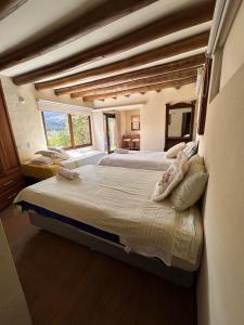 una grande camera da letto con due letti e una grande finestra di montaña serena a Villa de Leyva