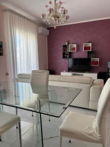 a living room with a glass table and a couch at Mariuccia Home in Siracusa +10 photos