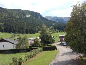 - une vue sur une ferme avec des montagnes en arrière-plan dans l'établissement Appartement 3 pièces + mezzanine, 6-8 pers., centre de Corrençon-en-Vercors, proche ski et golf - FR-1-515-116, à Corrençon-en-Vercors