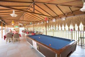 Ein Billardtisch in einem Pavillon, an dem Leute sitzen. in der Unterkunft Amphi Apart in Marmaris