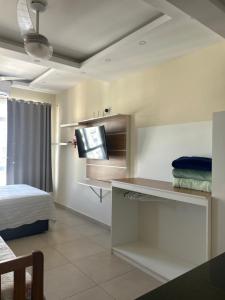 a room with a bed and a flat screen tv at COPACABANA RIO PRAIA 18 in Rio de Janeiro