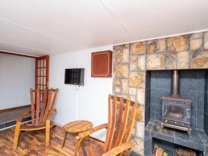 a living room with two chairs and a fireplace at Prima Rosa Langebaan - seaviews in Langebaan