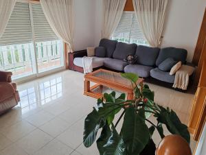 a living room with a blue couch and a table at El mirador de Monte Bouza in Monte Bouza