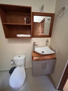 un bagno con un water bianco e un lavandino di montaña serena a Villa de Leyva