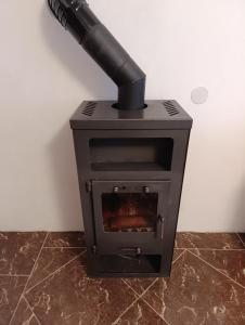 ein schwarzer Ofen mit einem Rohr darauf in der Unterkunft Apartman Kepić in Sirova Katalena