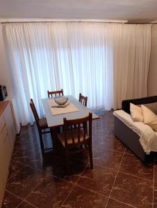 ein Wohnzimmer mit Tisch und Couch in der Unterkunft Apartman Kepić in Sirova Katalena