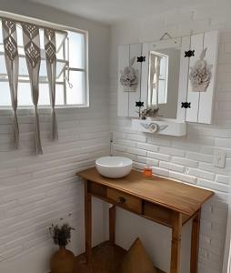 a white bathroom with a sink and a mirror at Casa Prana in Bragança Paulista