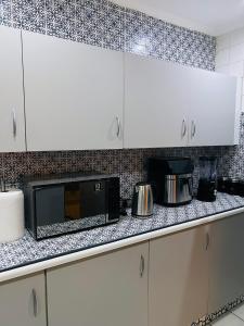a kitchen with white cabinets and a microwave on a counter at Suider home stay in Johannesburg