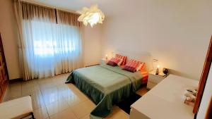 a bedroom with a bed with red pillows and a chandelier at El mirador de Monte Bouza in Monte Bouza +24 photos