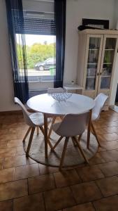 einen weißen Tisch und Stühle im Wohnzimmer in der Unterkunft Room New Zealand in Le Quesnoy