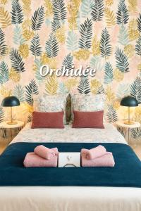 ein Schlafzimmer mit einem Bett mit rosa-goldener Tapete in der Unterkunft Les Epinettes chambres d'hôtes in Crèvecoeur-le-Grand