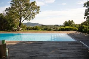 a person sitting in a chair next to a swimming pool at il cannito in Capaccio-Paestum