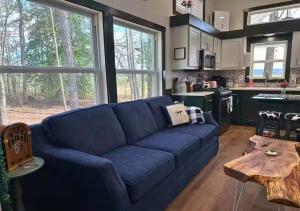 un salon avec un canapé bleu et une cuisine dans l'établissement Sunrise, Mountain & Farm View - Heated Tub or Pool, à Mentone