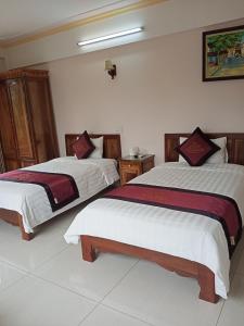 deux lits dans une chambre d'hôtel avec dans l'établissement Khách Sạn Thành Loan 2, à Nà Phia